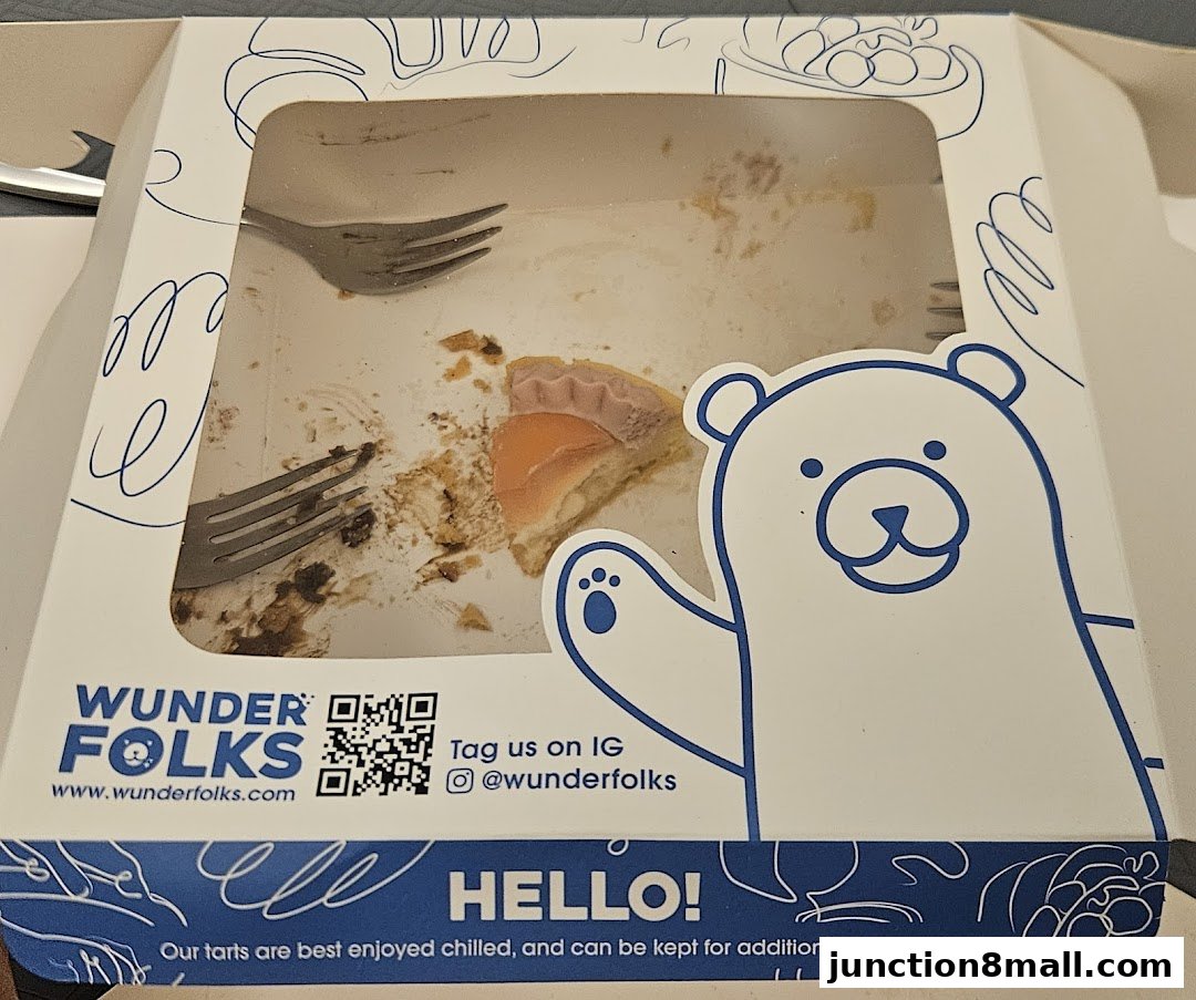 A partially eaten tart in a branded takeaway box with a cartoon bear.