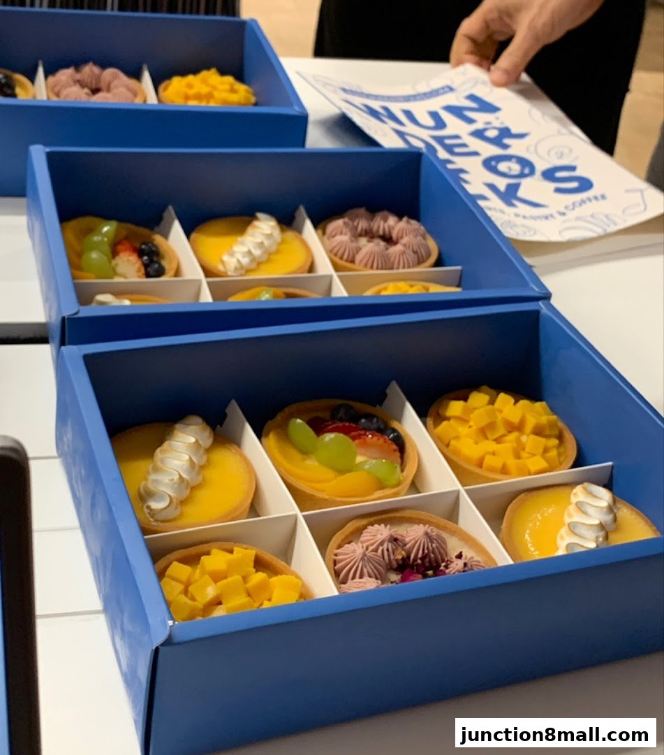 Boxes of assorted handmade tarts with various fruit and cream toppings.