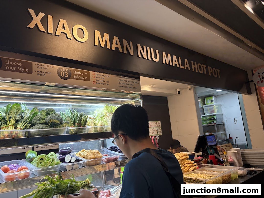 A customer selects ingredients at a Mala Hot Pot restaurant with a variety of fresh vegetables.