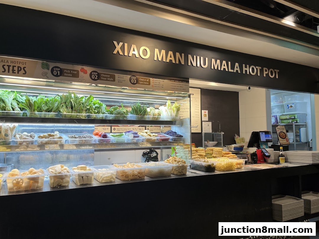 A display of fresh ingredients and prepared items at a Mala Hot Pot restaurant.