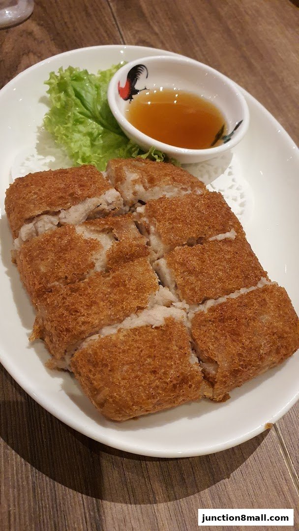 A plate of crispy fried dim sum with a side of dipping sauce and lettuce.