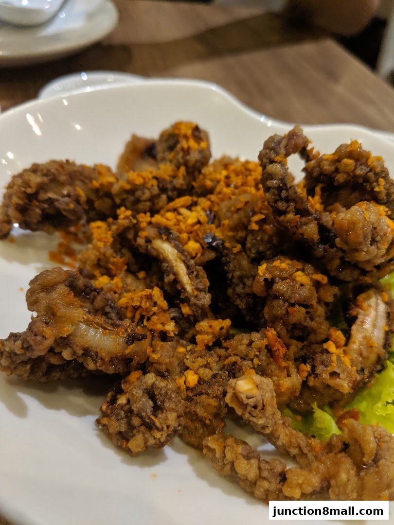 A plate of crispy fried calamari with garlic and chili seasoning.