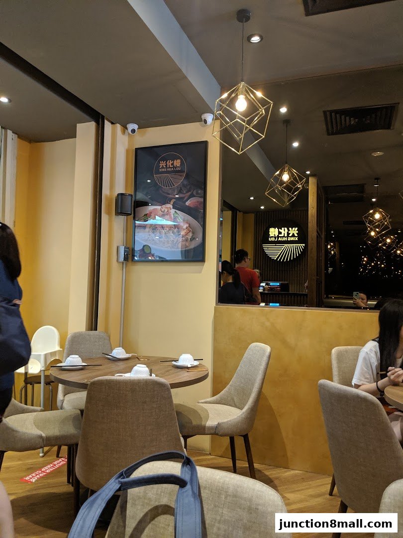 Interior view of Xing Hua Lou Express Bishan Food Junction with tables and chairs.