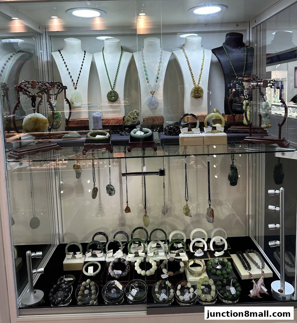 A display case filled with various jade necklaces, bracelets, and pendants.