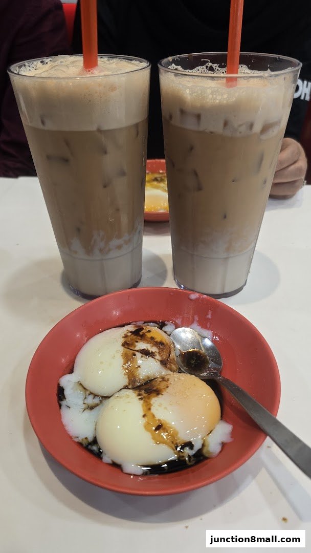 Two glasses of iced coffee and a bowl of soft-boiled eggs with soy sauce.