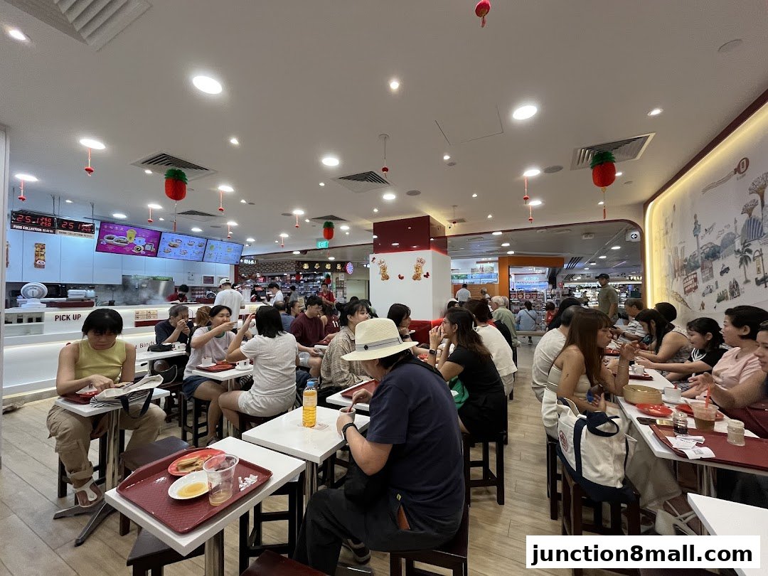 Customers dining at Ya Kun Kaya Toast, with a busy interior and food counter visible.