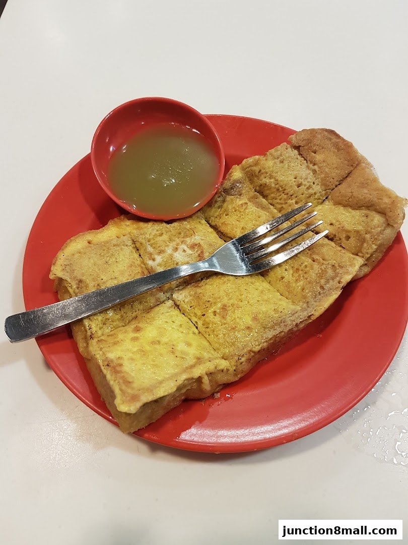 A plate of kaya toast with a small bowl of sauce and a fork.