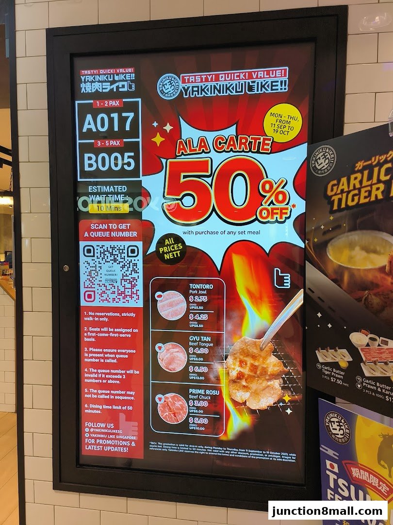 Digital display showing queue numbers, promotions, and menu items for Yakiniku Like.