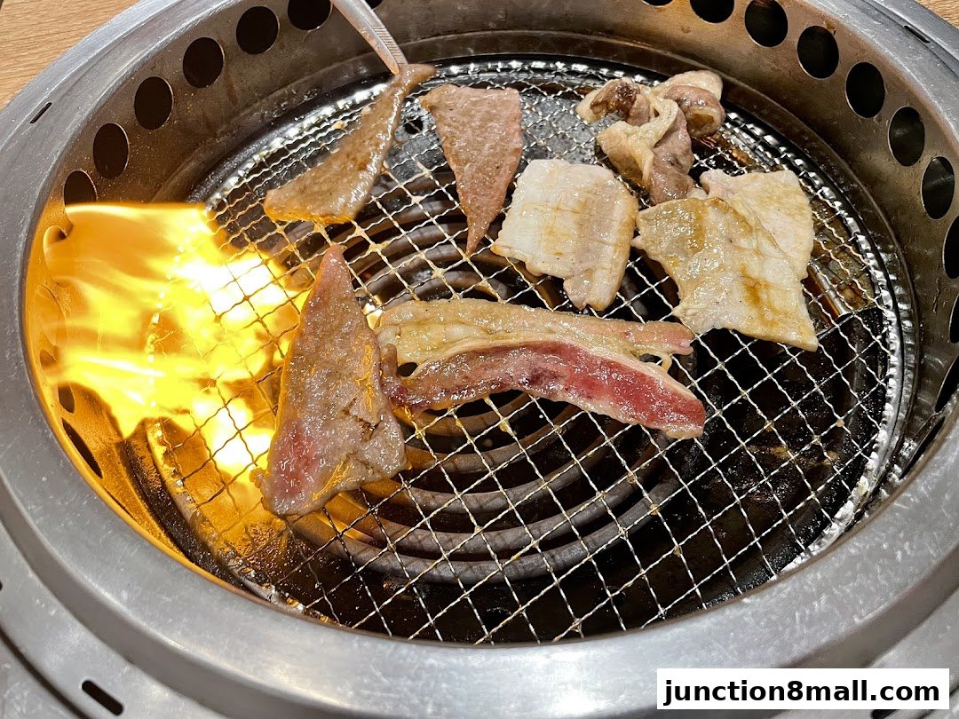 Sizzling cuts of meat grilling over open flames on a yakiniku grill.