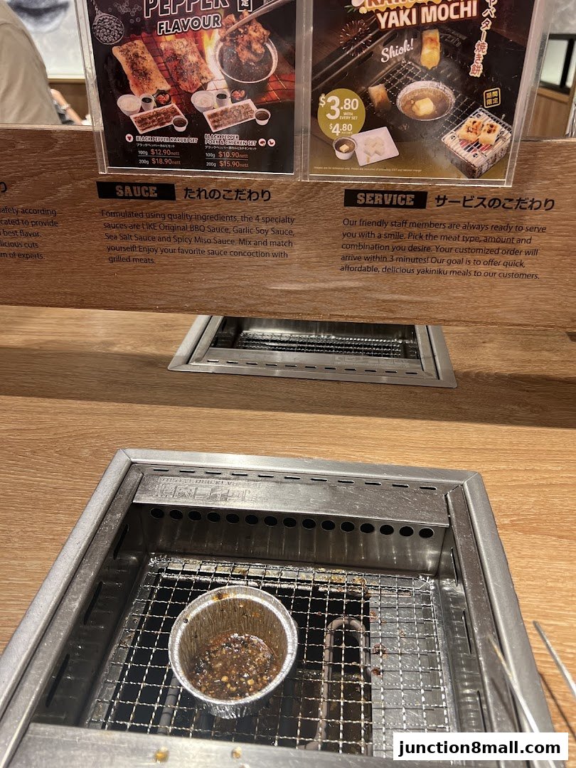 A close-up of a Yakiniku Like menu board showing different meat sets and sauces.