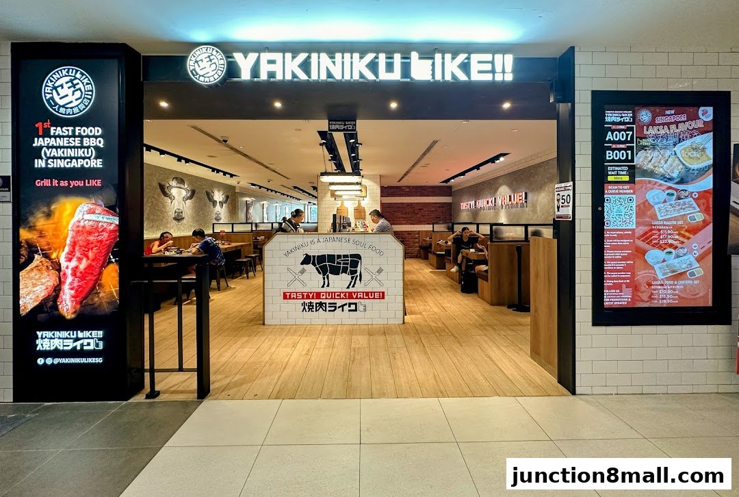 The entrance to Yakiniku Like, a Japanese BBQ restaurant, with a large advertisement for grilled meat.