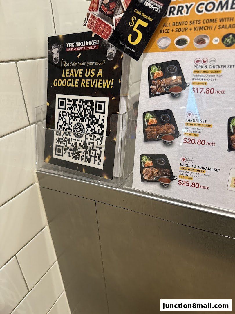 A menu board for Yakiniku Like Junction 8, featuring bento sets and a Google review QR code.