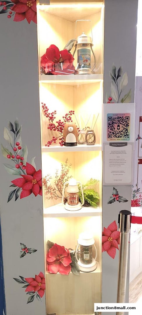 A display cabinet showcasing Yankee Candle products with festive holiday decorations.