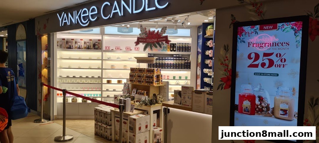The entrance of a Yankee Candle store, showcasing various candles and a promotional display.