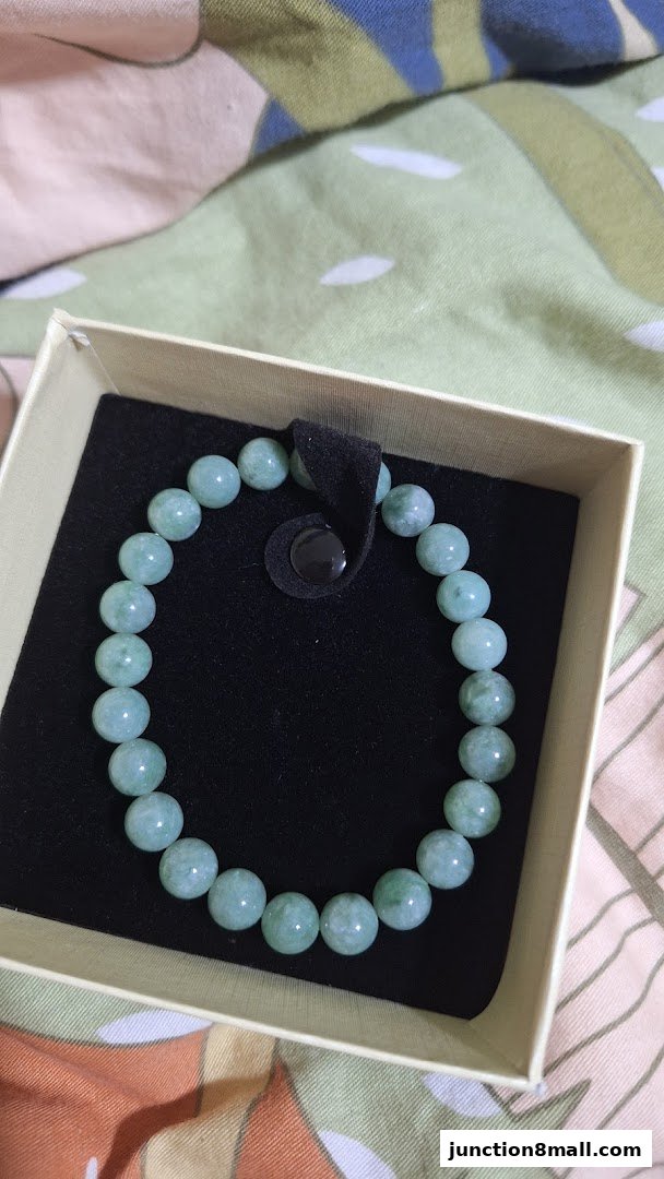 A jade bead bracelet is displayed in a light-colored gift box.