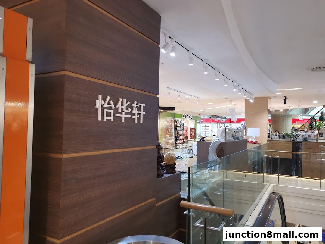 Interior view of a shopping mall with escalators and various shop displays.