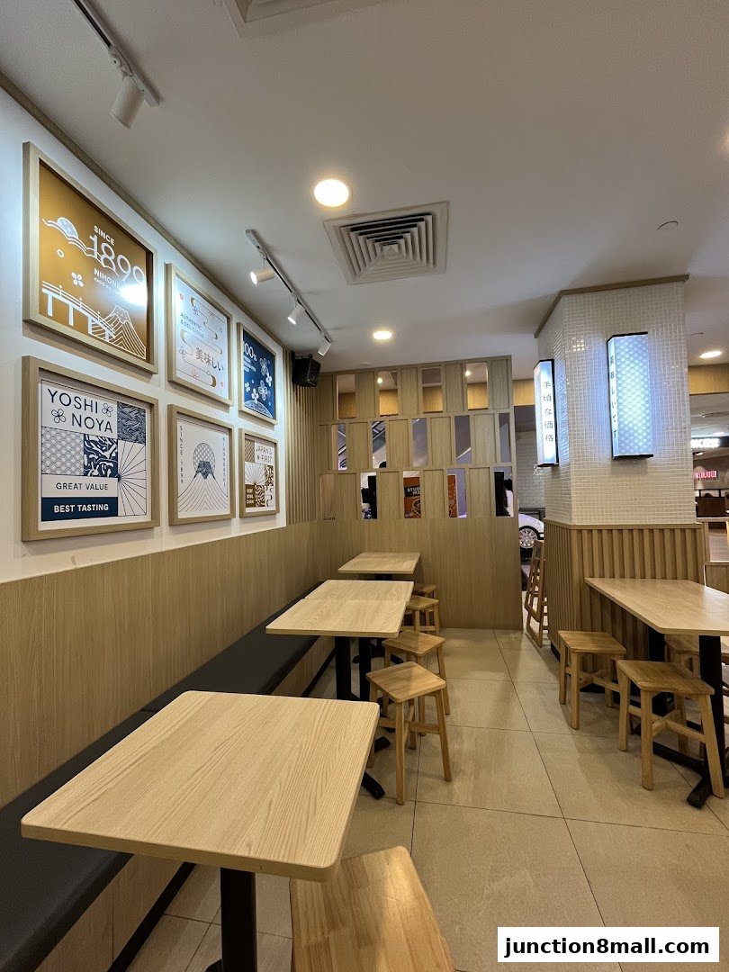 Interior view of Yoshinoya restaurant with tables, chairs, and decorative wall art.