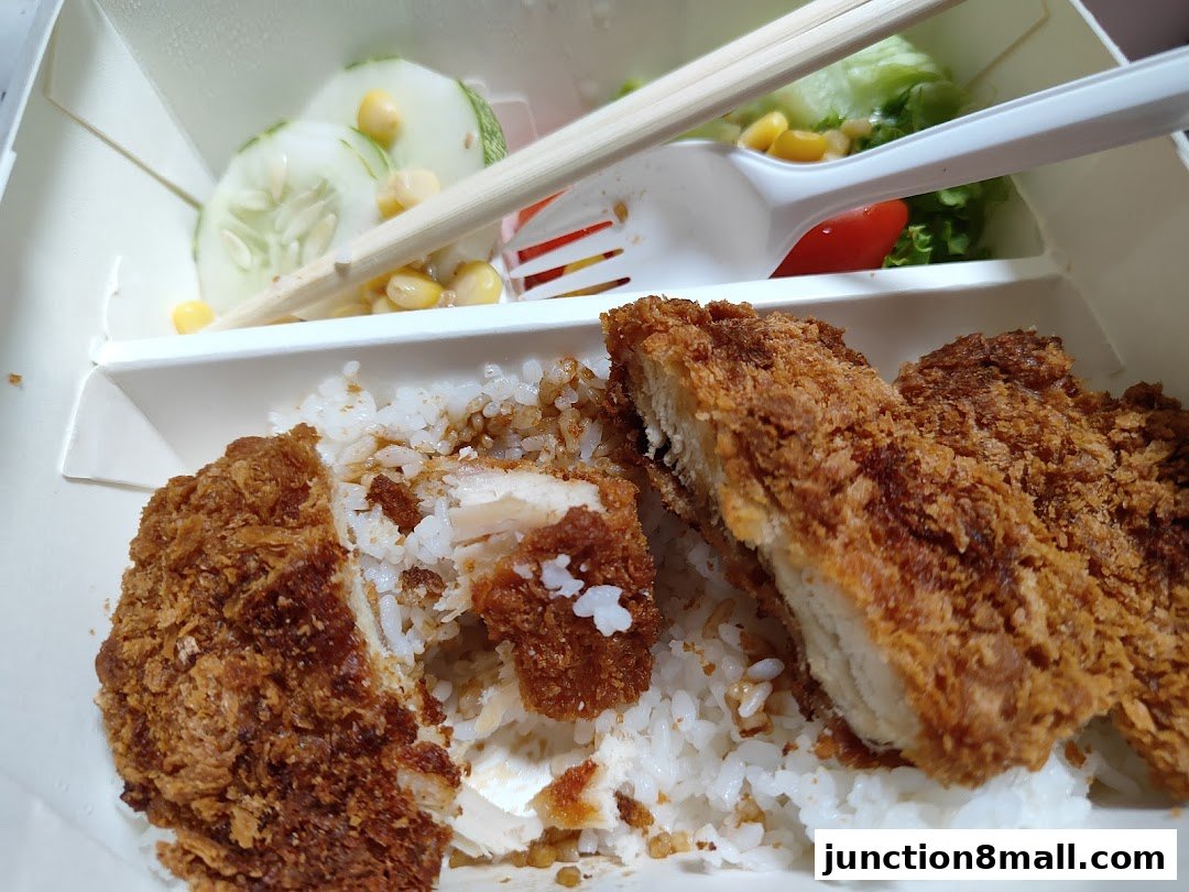 A close-up of a Yoshinoya meal with crispy fried chicken, rice, and a side salad.