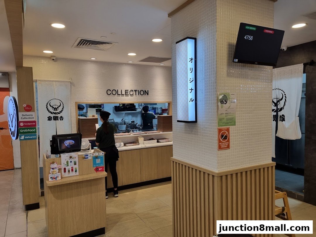 Interior view of a Yoshinoya restaurant with a collection counter and staff.