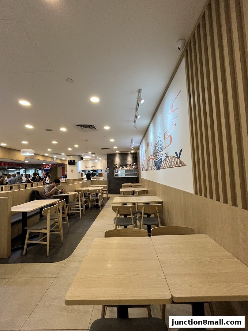 Interior view of a Yoshinoya restaurant with empty tables and a decorative wall.