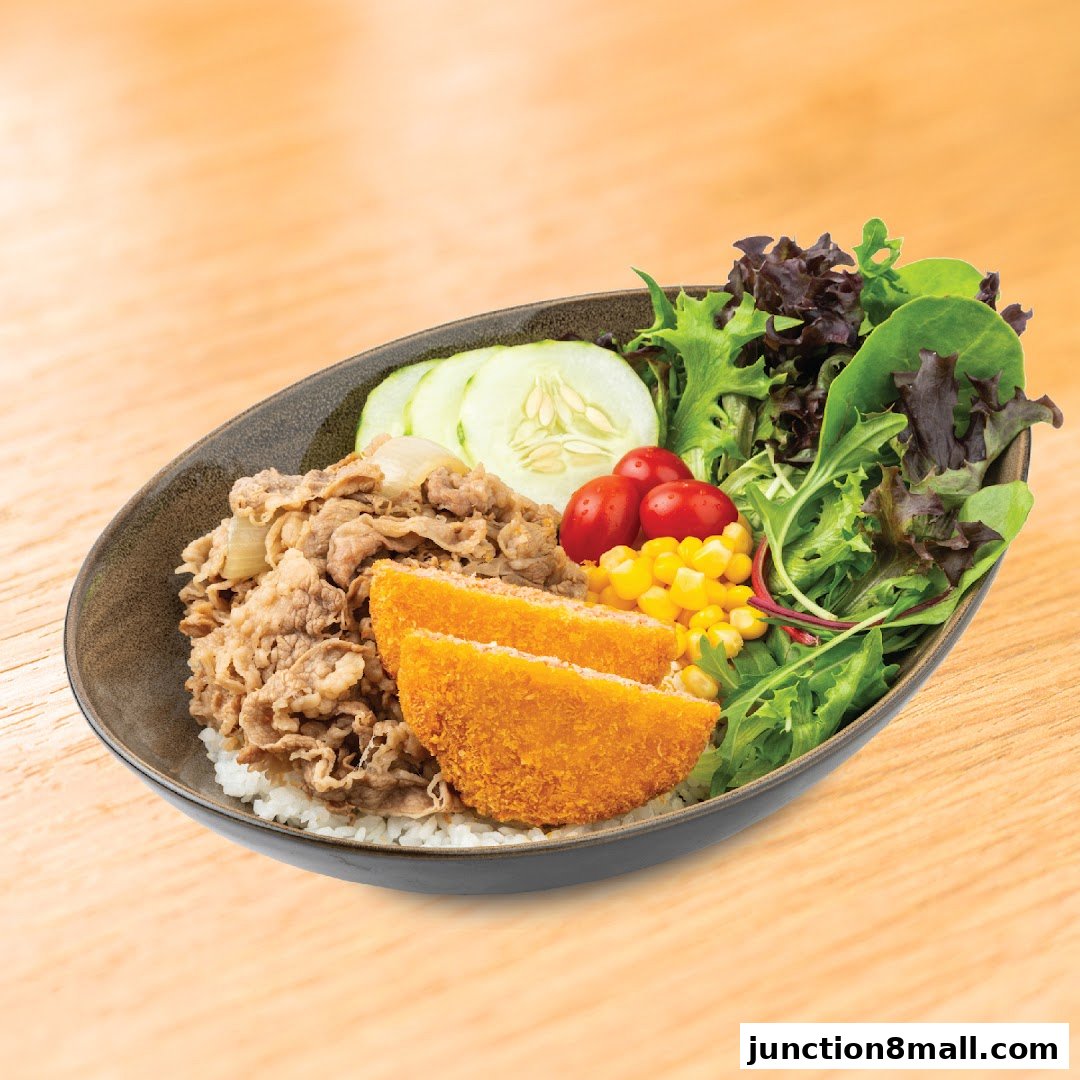 A delicious Yoshinoya beef bowl with rice, salad, corn, tomatoes, cucumber, and fried cutlets.