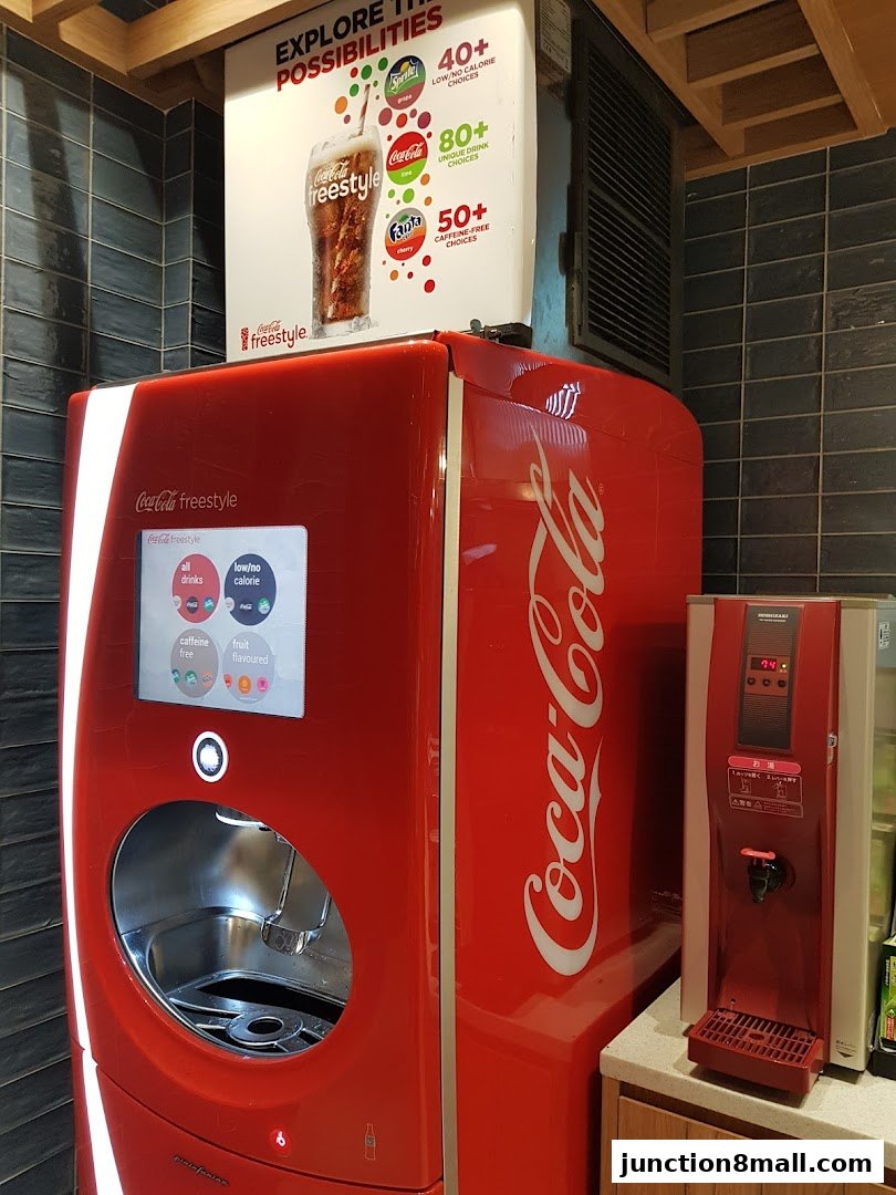 A Coca-Cola Freestyle machine with a sign advertising drink choices.