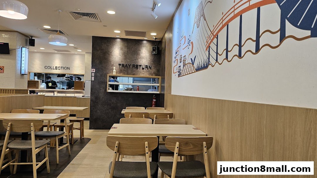 Interior of a Yoshinoya restaurant with tables, chairs, and a collection counter.