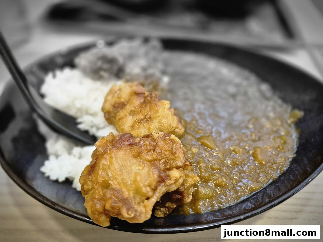 A close-up shot of a Yoshinoya dish featuring crispy fried chicken and rice with curry.